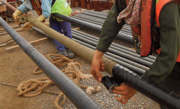 Workers applying Premtape Tropical System to Oil refinery Tie Rods