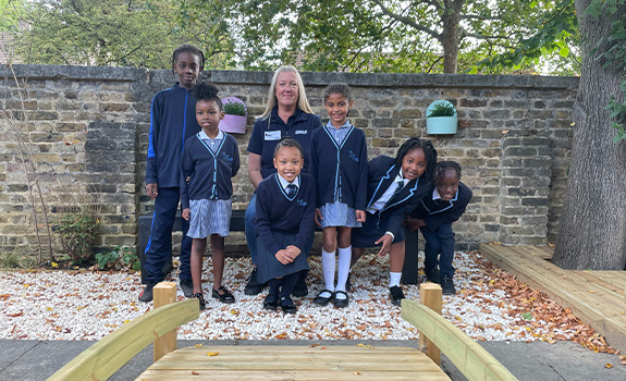Sarah from Winn & Coales posing with children from St Luke's School